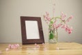 Flowers and white photo frame on wooden table Royalty Free Stock Photo