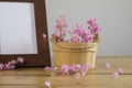 Flowers and white photo frame on wooden table Royalty Free Stock Photo