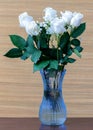 White roses with green leaves in a glass vase with water Royalty Free Stock Photo