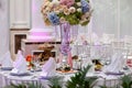 Flowers, wine glasses, napkins and salad on the table.