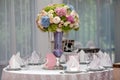 Flowers, wine glasses, napkins and salad on the table.