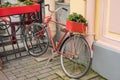 Flowers in a wooden box in the trunk of a red dyeing bike parked in the concrete walls of the house Royalty Free Stock Photo