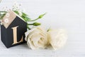 Flowers and wooden letter L on white table Royalty Free Stock Photo