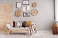 Flowers in yellow vase on wooden stool in beige scandinavian living room interior