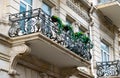 Flowery balcony in a city street. Flowerpots and house plants on the balcony. Classic style balcony with flowers