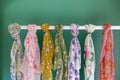 flowery scarves displayed on a white rack against a green backdrop Royalty Free Stock Photo