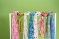 flowery scarves displayed on a white rack against a green backdrop Royalty Free Stock Photo