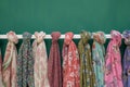 flowery scarves displayed on a white rack against a green backdrop Royalty Free Stock Photo