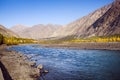 Flowing blue water of Gilgit River with mountains in the background, Pakistan.