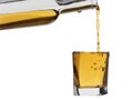 Flowing from a bottle of whisky in a glass on a white background Royalty Free Stock Photo