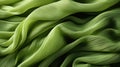 Flowing green satin fabric. Elegantly draped silky cloth