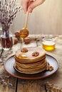 Flowing honey on stack of pancakes with nuts Royalty Free Stock Photo