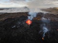 Flowing lava, hot magma spilling out of the volcano crater, aerial side view