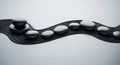 Smooth black stones arranged along a wavy, parallel-lined surface, creating a Royalty Free Stock Photo