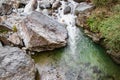 Flowing stream through green mossy rocks in forest, Royalty Free Stock Photo