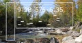 Flowing stream passing over rocks in mountain forest, with UI panel, code and binary digits Royalty Free Stock Photo