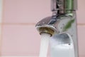 Flowing tap water run from corrosive steel spigot, flow on pink backdrop. Plumbing, bathroom apparatus and water flood Royalty Free Stock Photo