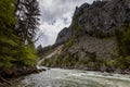 Flowing water next to old green railway bridge over wild river Enns in cloudy weather in Gesause National Park near town of Admont Royalty Free Stock Photo