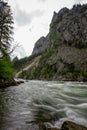 Flowing water next to old green railway bridge over wild river Enns in cloudy weather in Gesause National Park near town of Admont Royalty Free Stock Photo