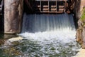 Flowing water with water spray from the open sluice gates of a small dam