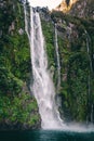 Flowing water fall into lake with green moss and leaves Royalty Free Stock Photo