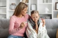 Flu Concept. Worried mother checking her daughter's temperature at home Royalty Free Stock Photo