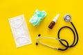 Flu drops. Running nose concept. Wrinkled napkin near stethoscope and face mask on yellow background top view Royalty Free Stock Photo