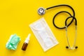 Flu drops. Running nose concept. Wrinkled napkin near stethoscope and face mask on yellow background top view copy space Royalty Free Stock Photo