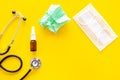 Flu drops. Running nose concept. Wrinkled napkin near stethoscope and face mask on yellow background top view copy space Royalty Free Stock Photo