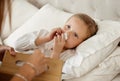 Flu flu, go away. a little girl feeling ill in bed at home and blowing her nose. Royalty Free Stock Photo