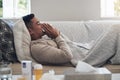 Flu season is here. a young man blowing his nose while feeling sick at home. Royalty Free Stock Photo