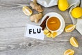 FLU - written on piece of paper among the products for the treatment of common cold - lemon, ginger, chamomile tea. Vitamin