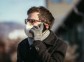 Flue and corona safety concept. Man wearing face mask to protect himself, outdoors
