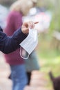 Flue and corona safety concept. Woman holding single use face mask, outdoors