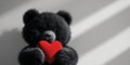 Fluffy Black Creature Holding a Red Heart. Royalty Free Stock Photo