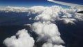 Fluffy clouds and snowy mountains  View from plane window Royalty Free Stock Photo