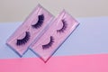 Fluffy cosmetic false eyelashes on paper geometric background. Royalty Free Stock Photo
