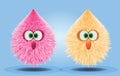 Fluffy and furry pompons in pink and orange yellow color on blue background for toy presentation Royalty Free Stock Photo