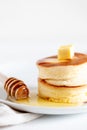 Fluffy Japan souffle pancakes, hotcakes with butter and maple syrup or honey sauces on light white background Royalty Free Stock Photo