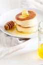 Fluffy Japan souffle pancakes, hotcakes with butter and maple syrup or honey sauces on light white background