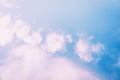 Fluffy light pink clouds on a blue sky background