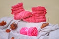 fluffy pink home slippers and rolled scarf on knitted white blanket, cozy autumn image Royalty Free Stock Photo