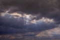 Fluffy rain clouds before rain with sunbeams shining through them