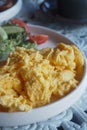 Fluffy scrambled eggs served with fresh salad Royalty Free Stock Photo