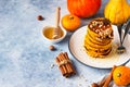 Fluffy spicy pumpkin pancakes with honey and nuts, fresh pumpkins and spices on blue stone background Royalty Free Stock Photo