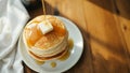 A fluffy stack of buttermilk pancakes, butter melting on top