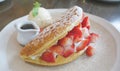 Fluffy strawberry cream waffle with ice cream and syrup