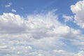 Fluffy and whispy clouds almost cover pretty blue sky