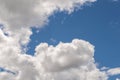 Fluffy white billowy clouds brightly back lit, blue sky.