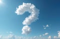 Fluffy white cloud forms question mark shape against clear blue sky. Bright sun shines, casting light on cumulus formations. Royalty Free Stock Photo